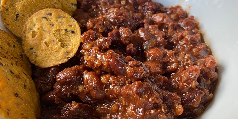 Vegan chili in a bowl with sweet potato chips