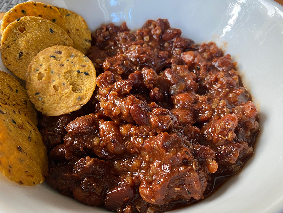 Vegan chili in a bowl with sweet potato chips