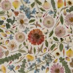 a pressed wedding flower bouquet is arranged into a mosaic collage on cream paper.